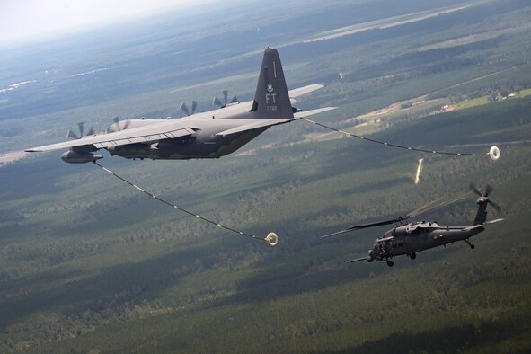 An HH-60G Pave Hawk from the 41st Rescue Squadron approaches an HC-130J Combat King II from the 71st RQS to conduct aerial refueling during 23d Wing commander Col. Thomas Kunkel’s fini-flight, June 27, 2017, at Moody Air Force Base, Ga. The fini-flight is a long-standing Air Force tradition that occurs when a pilot departs from the base. Upon completion of their final flights, military aviators are hosed down with water or champagne by their family and friends before they depart their unit. (U.S. Air Force photo by Staff Sgt. Ryan Callaghan)
