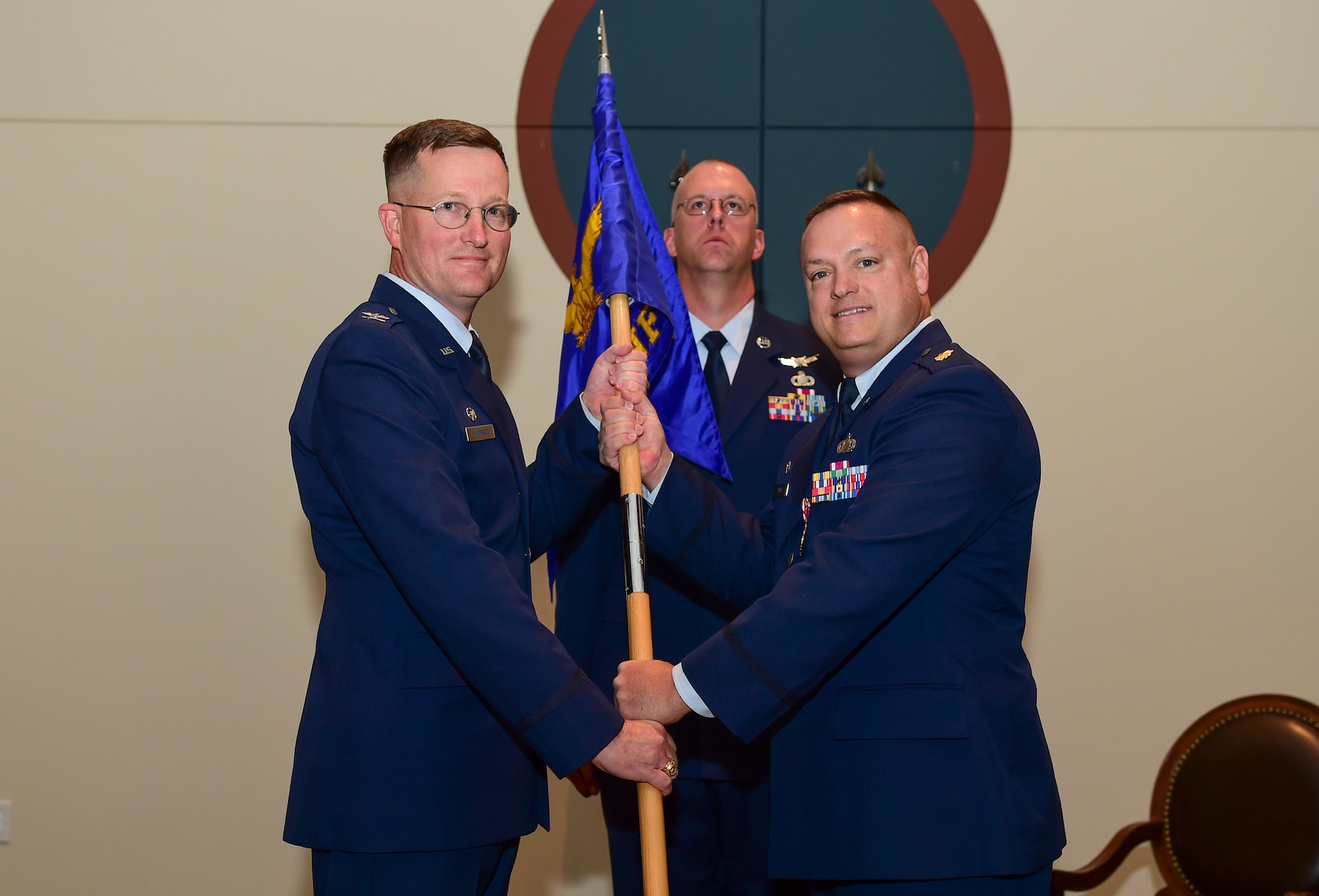 Maj. Gene Smith, 460th Contracting Flight outgoing commander, relinquishes the guidon to Col. Shawn Thompson, 460th Mission Support Group commander, June 28, 2017, on Buckley Air Force Base, Colo. The 460th CONF supports the base with millions of dollars in contracts each year. (U.S. Air Force photo by Airman Jacob Deatherage/Released)