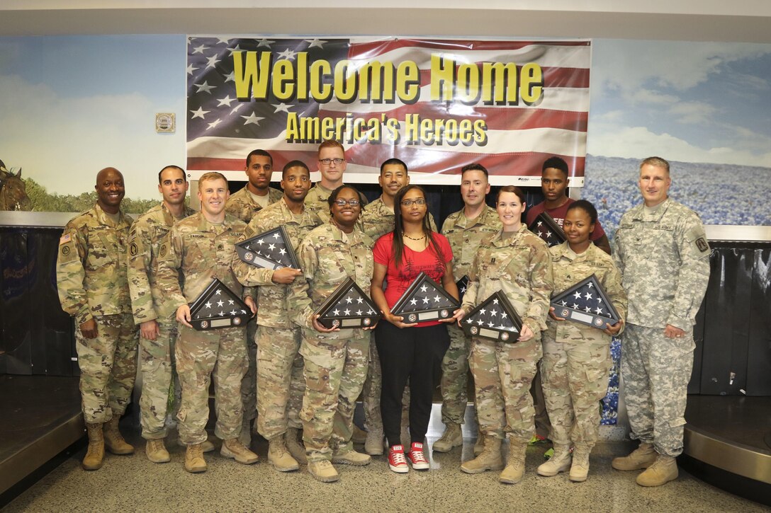 A team of twelve Soldiers, assigned to Detachment 1, 335th Signal Command (Theater), pose for a photo at the Killeen Regional Airport, Killeen, Texas after returning from a successful nine-month deployment June 28.  The Soldiers deployed last year with a mission of providing communications support to a special operations joint task force, as part of Operation Inherent Resolve.  Also in the photo are Col. Todd Peterson (far right), force management director and acting G-3 operations officer, 335th SC (T), and Command Sgt. Maj. Ronnie Farmer (far left), command sergeant major, 335th SC (T) who were on hand to welcome the Soldiers back home.  (Official U.S. Army Reserve photo by Sgt. 1st Class Brent C. Powell)