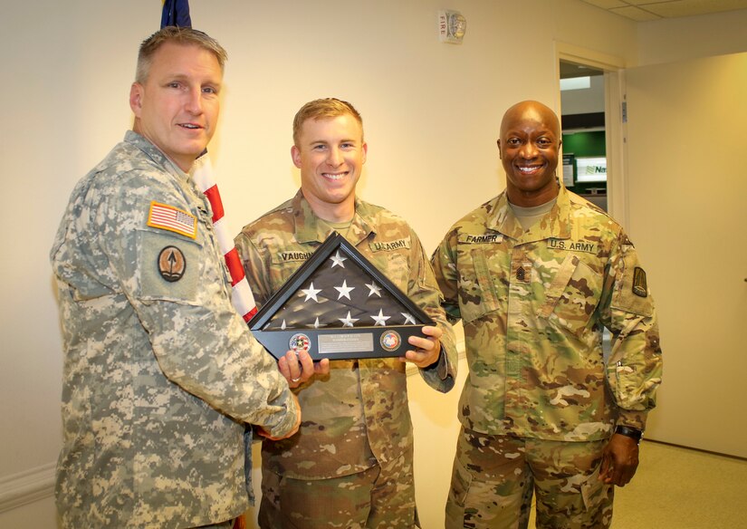 Col. Todd Peterson (left), force management director and acting G-3 operations officer, 335th Signal Command (Theater), and Command Sgt. Maj. Ronnie Farmer (right), command sergeant major, 335th SC (T) pose with Staff Sgt. Lewis Vaughn, noncommissioned officer-in-charge of the service desk for Detachment 1, 335th SC (T), after presenting Vaughn with an American flag and display case during a welcome home warrior citizen ceremony at the Killeen Regional Airport, Killeen, Texas June 28.  Vaughn and 11 other Soldiers returned from a nine-month deployment where their mission was providing communications support to a special operations joint task force, as part of Operation Inherent Resolve.  (Official U.S. Army Reserve photo by Sgt. 1st Class Brent C. Powell)