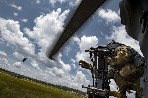 Tech. Sgt. Brandon Middleton, 41st Rescue Squadron special missions aviator, tosses a smoke grenade from an HH-60G Pave Hawk, June 27, 2017, at Moody Air Force Base, Ga. The HH-60G flies with two pilots and two SMAs, who are responsible for pre-flight aircraft inspections, passengers, cargo and operating the aircraft’s weapons. (U.S. Air Force photo by Staff Sgt. Ryan Callaghan)
