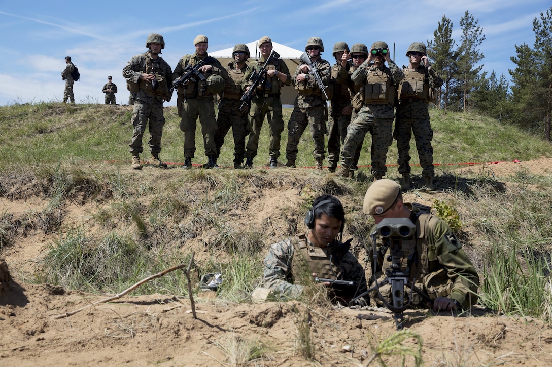 U.S. Marines and Norwegian soldiers look on as a Marine assigned to Black Sea Rotational Force 17.1 explains procedures to a Norwegian soldier during Exercise Saber Strike 17 at Adazi Military Base, Latvia, June 9, 2017. Marine Corps photo by Sgt. Patricia A. Morris