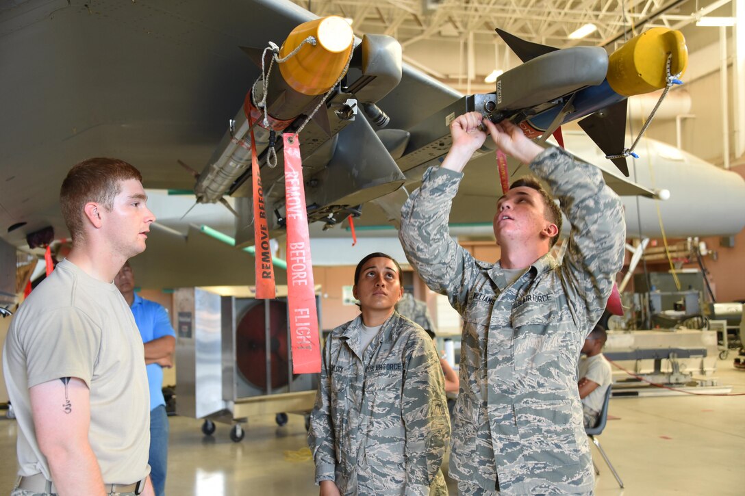 Airmen Bradd Hammond, Tyana Haylock and Anthony Williams, 363rd Training Squadron F-15 Eagle aircraft armament systems apprentice students perform functional checks of launch and suspension systems at Sheppard Air Force Base, Texas. Students learn to maintain launch and release devices and also load munitions onto them. (U.S. Air Force photo/Liz H. Colunga)
