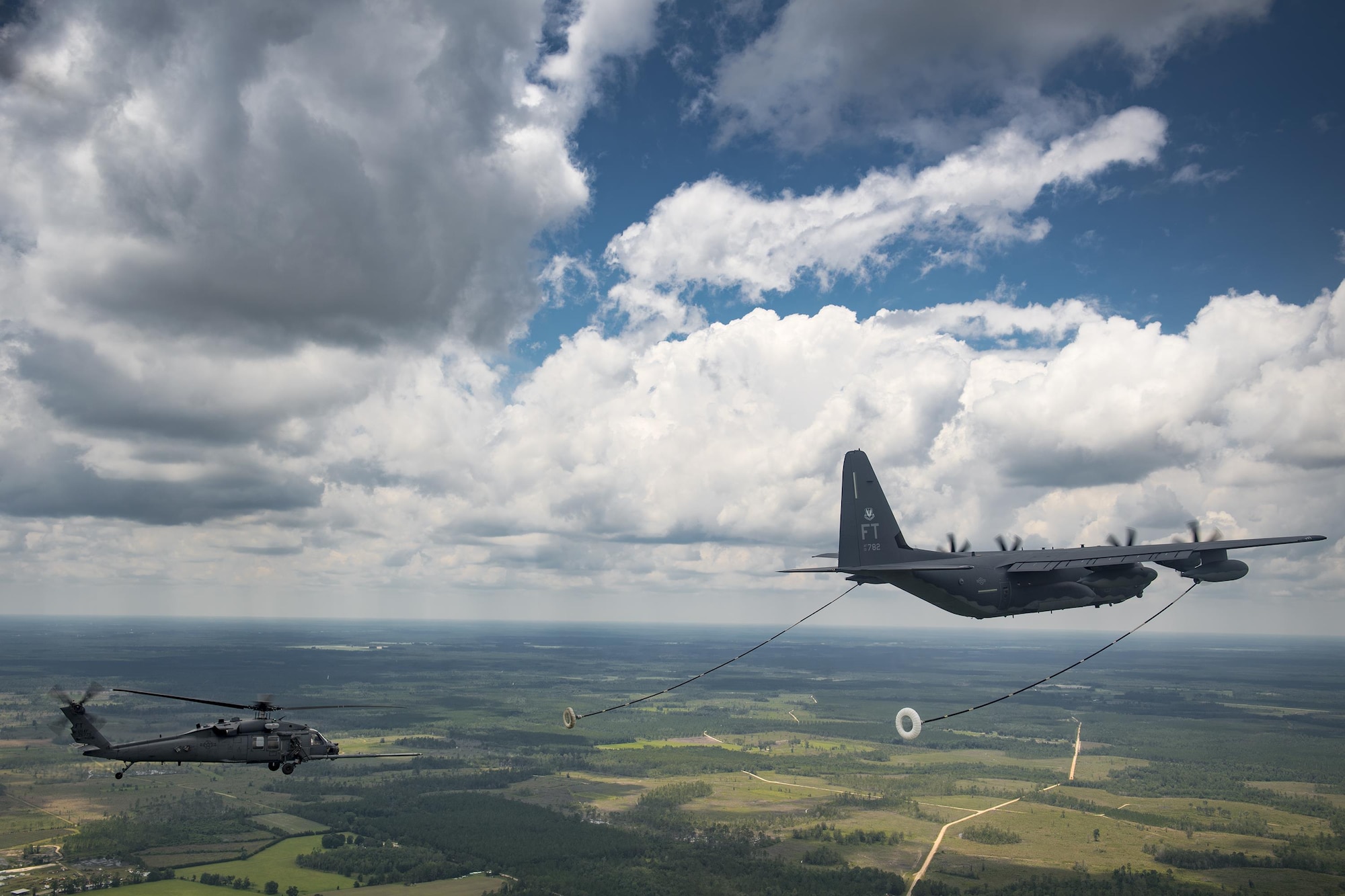 An HH-60G Pave Hawk from the 41st Rescue Squadron approaches an HC-130J Combat King II from the 71st RQS to conduct aerial refueling during 23d Wing commander Col. Thomas Kunkel’s fini-flight, June 27, 2017, at Moody Air Force Base, Ga. The fini-flight is a long-standing Air Force tradition that occurs when a pilot departs from the base. Upon completion of their final flights, military aviators are hosed down with water or champagne by their family and friends before they depart their unit. (U.S. Air Force photo by Staff Sgt. Ryan Callaghan)