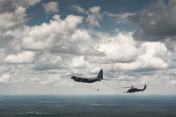 An HH-60G Pave Hawk from the 41st Rescue Squadron approaches an HC-130J Combat King II from the 71st RQS to conduct aerial refueling during 23d Wing commander Col. Thomas Kunkel’s fini-flight, June 27, 2017, at Moody Air Force Base, Ga. The fini-flight is a long-standing Air Force tradition that occurs when a pilot departs from the base. Upon completion of their final flights, military aviators are hosed down with water or champagne by their family and friends before they depart their unit. (U.S. Air Force photo by Staff Sgt. Ryan Callaghan)