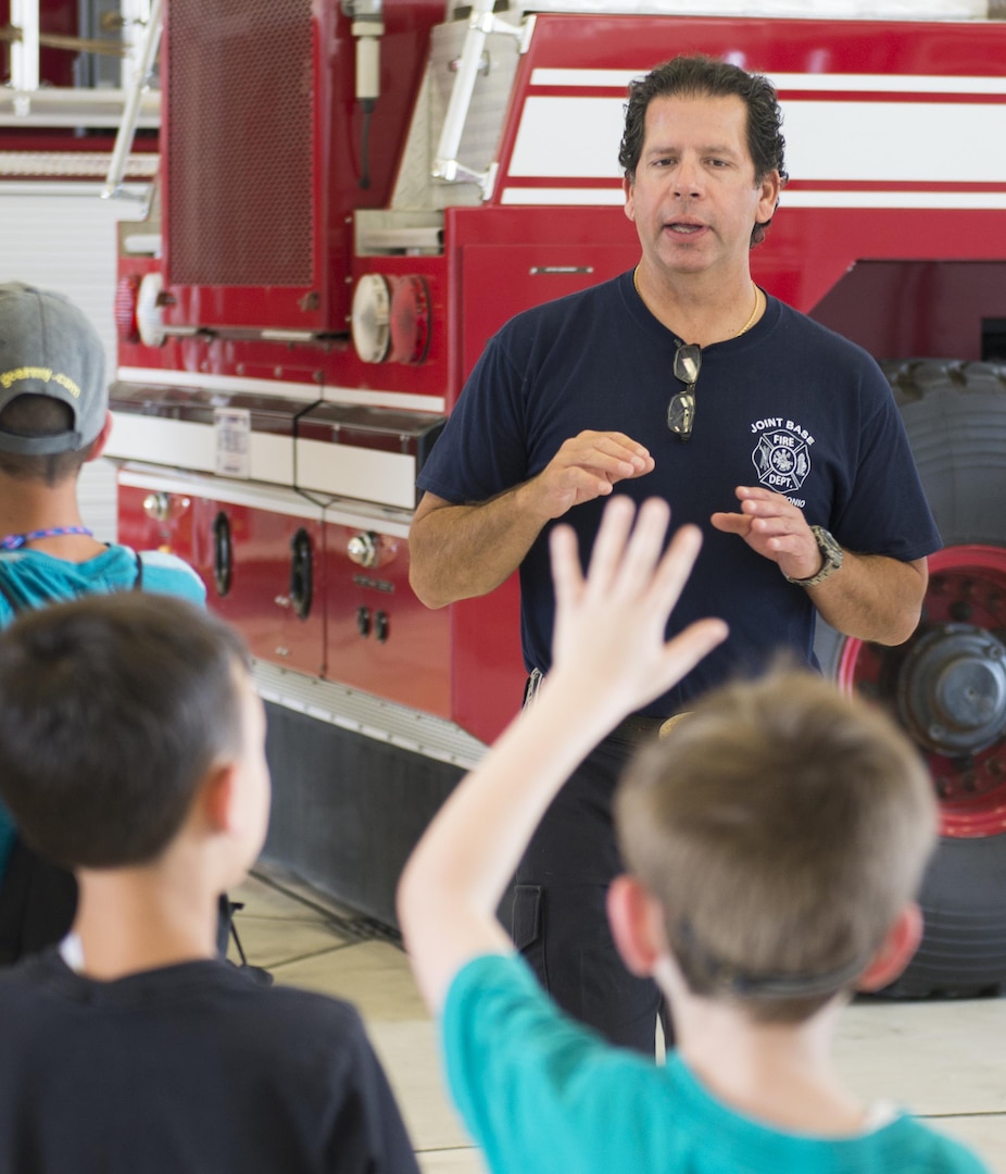 Michael Martinez, 502nd Civil Engineering Squadron firefighter, answers questions about fire safety during a open house tour of Fire Station 2 June 23, 2017, at Joint Base San Antonio-Lackland, Texas. The firefighter hosted a tour for five autistic children with Vibrant ABA Solutions and provided them with fire safety tips. (U.S. Air Force photo by Senior Airman Krystal Wright)