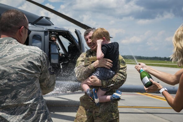 Family and fellow Airmen spray Col. Thomas Kunkel, 23d Wing commander, with champagne after his fini-flight, June 27, 2017, at Moody Air Force Base, Ga. The fini-flight is a long-standing Air Force tradition that occurs when a pilot departs from the base. Upon completion of their final flights, military aviators are hosed down with water or champagne by their family and friends before they depart their unit. (U.S. Air Force photo by Airman 1st Class Lauren M. Sprunk) 