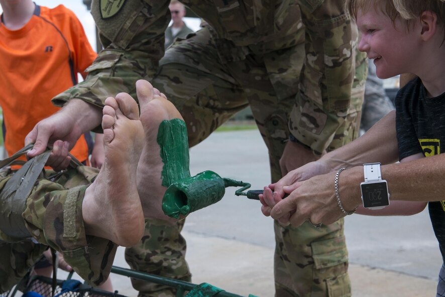 Family members paint the feet of Col. Thomas Kunkel, 23d Wing commander, after his fini-flight, June 27, 2017. His painted feet were then placed on a ceiling tile to be hung in the 41st Rescue Squadron. This process is usually done after pilot complete their fini-flight, a long-standing Air Force tradition that occurs when a pilot departs from the base. (U.S. Air Force photo by Airman 1st Class Lauren M. Sprunk)