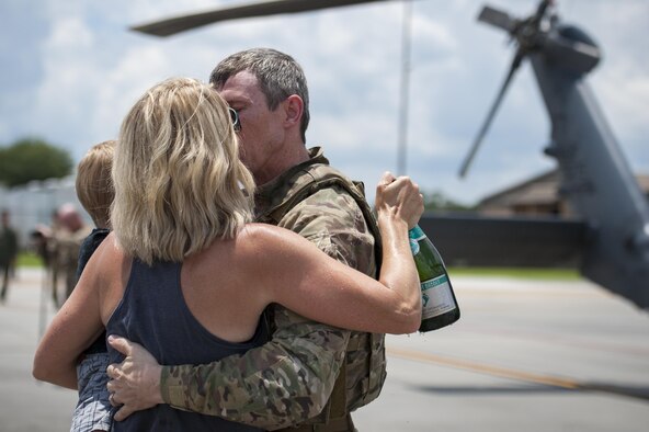 Col. Thomas Kunkel, 23d Wing commander, embraces his family after completing his fini-flight, June 27, 2017, at Moody Air Force Base, Ga. The fini-flight is a long-standing Air Force tradition that occurs when a pilot departs from the base. Upon completion of their final flights, military aviators are hosed down with water or champagne by their family and friends before they depart their unit. (U.S. Air Force photo by Airman 1st Class Lauren M. Sprunk)