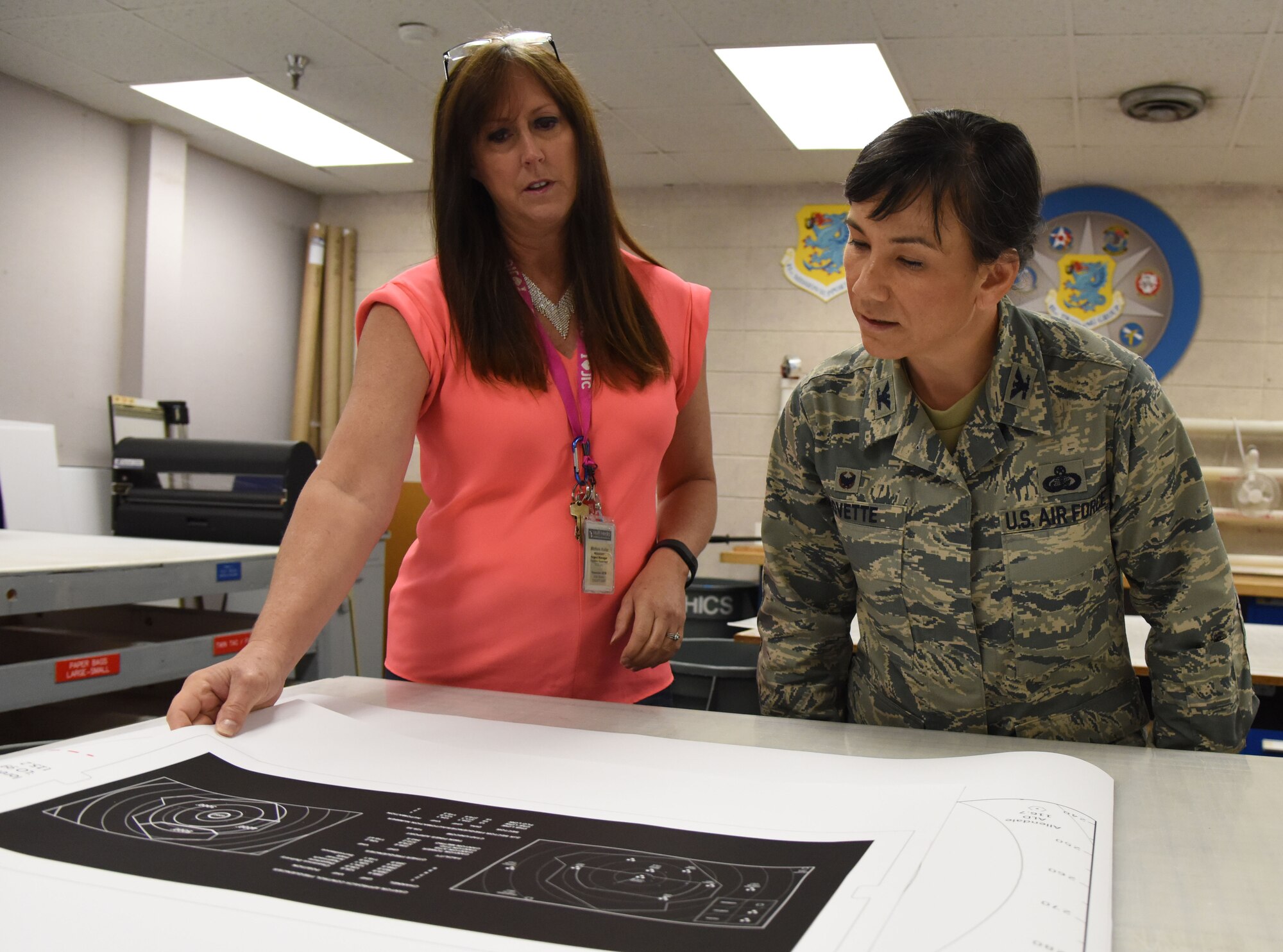 Michele Keller, 81st Training Wing public affairs graphic illustrator, shows Col. Debra Lovette, 81st TRW commander, an example of a graphic illustration at Wall Studio during a Wing Staff Agency orientation tour June 27, 2017, on Keesler Air Force Base, Miss. The tour familiarized Lovette with the Wing Staff Agency mission, operations and personnel. (U.S. Air Force photo by Kemberly Groue)