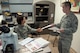 Staff Sgt. Steven Lam, Wright-Patterson Medical Center histology technician, provides Maj. (Dr.) Luisa Watts, staff pathologist, additional information for a pending case. Watts, along with three other staff pathologists at the WPMC, use information doctors provide, along with reviews of biological materials and reference materials, in forming their diagnoses. (U.S. Air Force photo/John Harrington)