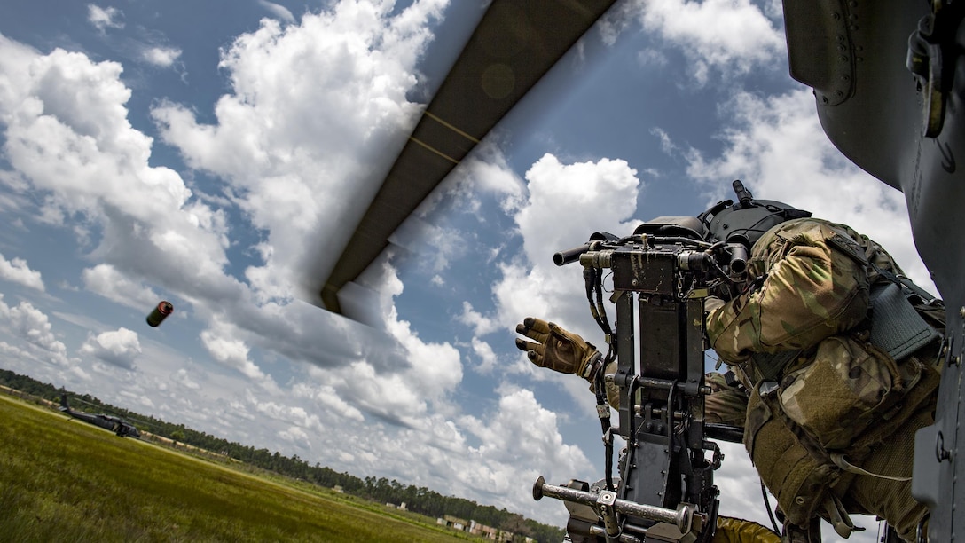 Air Force Tech. Sgt. Brandon Middleton tosses a smoke grenade from an HH-60G Pave Hawk helicopter during training at Moody Air Force Base, Ga., June 27, 2017, Middleton is a special missions aviator assigned to the 41st Rescue Squadron. Air Force photo by Staff Sgt. Ryan Callaghan