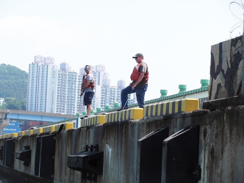 Adam Hamm (Buffalo District) and Steve England (Philadelphia District) tending a diver conducting an inspection of the underwater portion of Busan Pier 8 in Busan, South Korea on June 5, 2017.