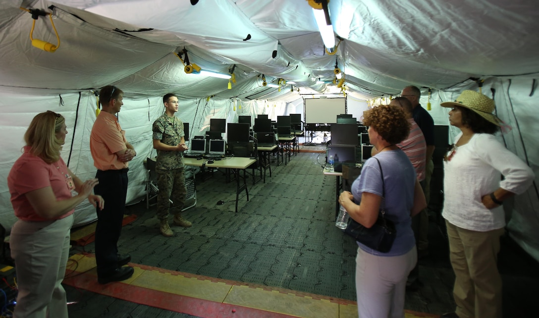 Lance Cpl. Wade Lander leads a tour of personnel from Program Executive Officer Land Systems through the Common Aviation Command and Control System aboard Marine Corps Air Station Cherry Point, N.C. June 28, 2017. The CAC2S system will provide a complete and coordinated modernization of Marine Air Command and Control System equipment, improving expeditionary capabilities while reducing size and time requirements for Marine Air-Ground Task Force commanders. The CAC2S will interface with the Composite Tracking Network and Ground/Air Task Oriented Radar to improve the situational awareness and decision making ability of MAGTF COs. Lander is a tactical air defense controller assigned to Marine Air Control Squadron 2, Marine Air Control Group 28, 2nd Marine Aircraft Wing. (U.S. Marine Corps Photo by Pfc. Skyler Pumphret/ Released)