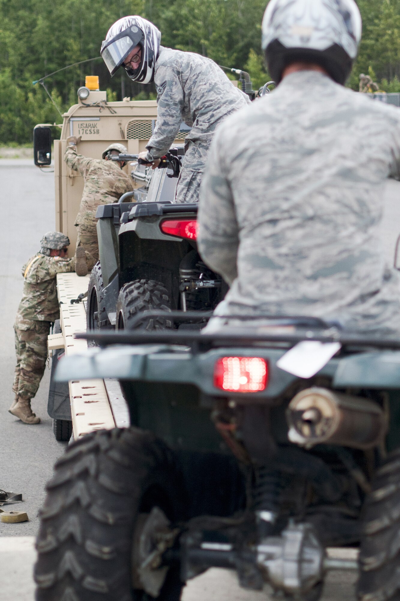 Senior Airman Adrian Durr, a native of Terre Haute, Ind., assigned to the 673rd Security Forces Squadron, watches his spacing after loading an all-terrain vehicle onto a flat bed trailer being secured by Soldiers assigned to the 109th Transportation Company "Muleskinners", 17th Combat Sustainment Support Battalion, U.S. Army Alaska, on Joint Base Elmendorf-Richardson, Alaska, June 28, 2017, in support of a U.S. Air Force exercise. USARAK is at the forefront  of protecting America’s interests in the Asia-Pacific region, and is one of the U.S. military’s most centrally located power projection platforms that benefits from joint training opportunities.