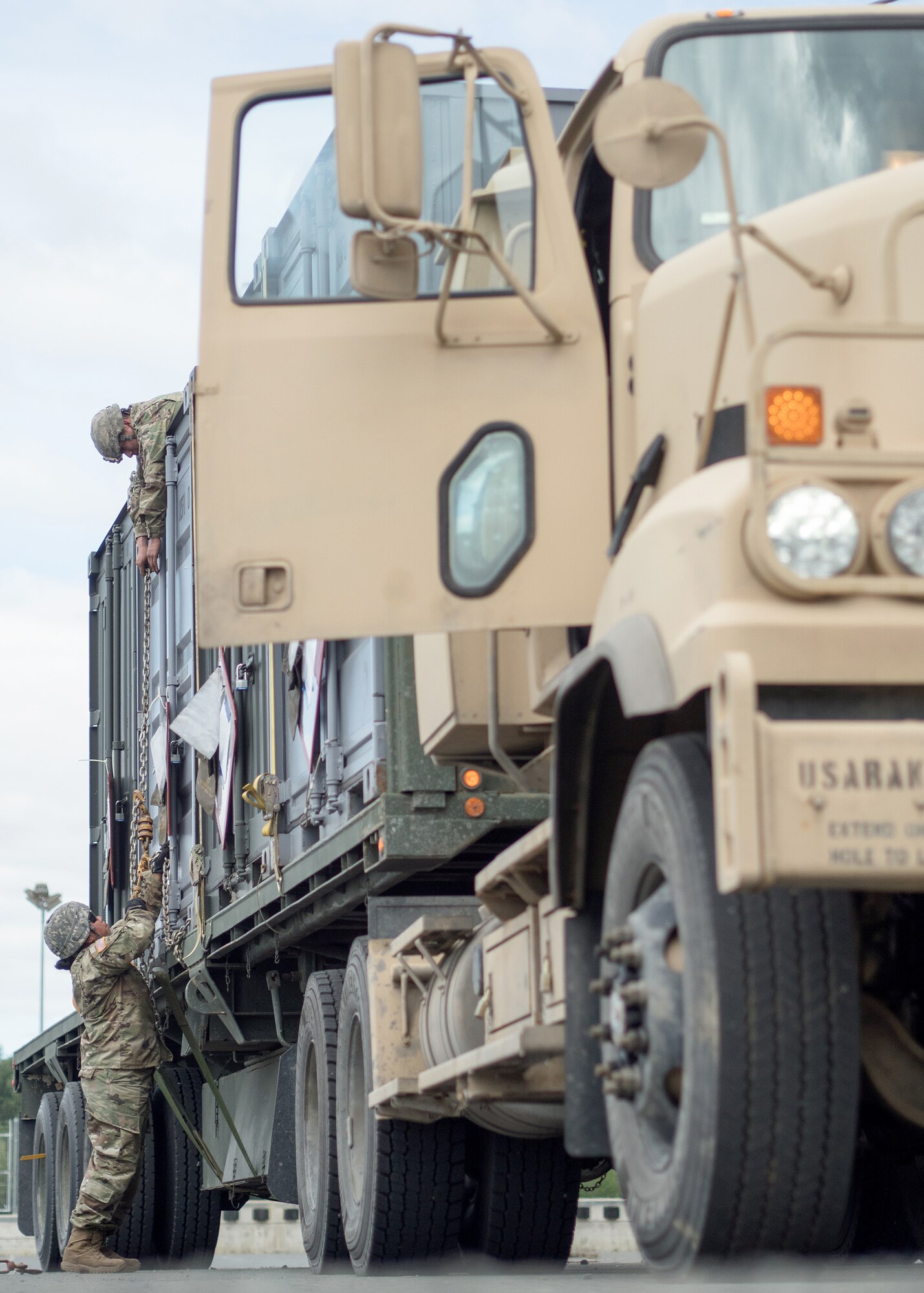 Spc. Jorge MillerGarcia, a native of Sheboygan, Wis., top, and Army Staff Sgt. Igoa Lilii, a native of Garden Grove, Calif., both assigned to the 109th Transportation Company "Muleskinners", 17th Combat Sustainment Support Battalion, U.S. Army Alaska, secure equipment on a flat bed trailer at Joint Base Elmendorf-Richardson, Alaska, June 28, 2017, in support of a U.S. Air Force exercise. USARAK is at the forefront  of protecting America’s interests in the Asia-Pacific region, and is one of the U.S. military’s most centrally located power projection platforms that benefits from joint training opportunities.