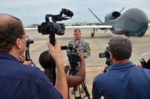 Brig. Gen. John Kubinec, Warner Robins Air Logistics Complex commander, speaks with local media June 29, following a special ribbon cutting ceremony which signaled the early completion of work on the first RQ-4 Global Hawk at Robins Air Force Base, Ga. The base is the first and only installation to have a building-based Launch and Recovery Element, allowing the aircraft to take off and land from this location. This is also the first time a Global Hawk has flown into an Air Force air logistics complex. Team Robins maintenance professionals meticulously painted the aircraft to prevent corrosion. (U.S. Air Force photo/TECH. SGT. KELLY GOONAN)