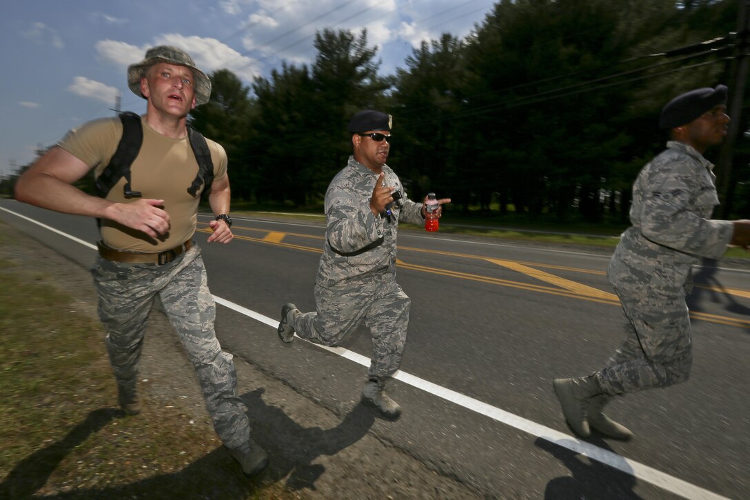 U.S. Air Force Airman 1st Class Travis Roemmele, left, from the New Jersey Air National Guard's 108th Security Forces Squadron finishes the 12km foot march with fellow airmen helping him along during a German Armed Forces Badge for Military Proficiency test at Joint Base McGuire-Dix-Lakehurst, N.J., June 13, 2017. The test included an 1x10-meter sprint, flex arm hang, 1,000 meter run, 100 meter swim in Military Uniform, marksmanship, and a timed foot march. (U.S. Air National Guard photo by Master Sgt. Matt Hecht/Released)