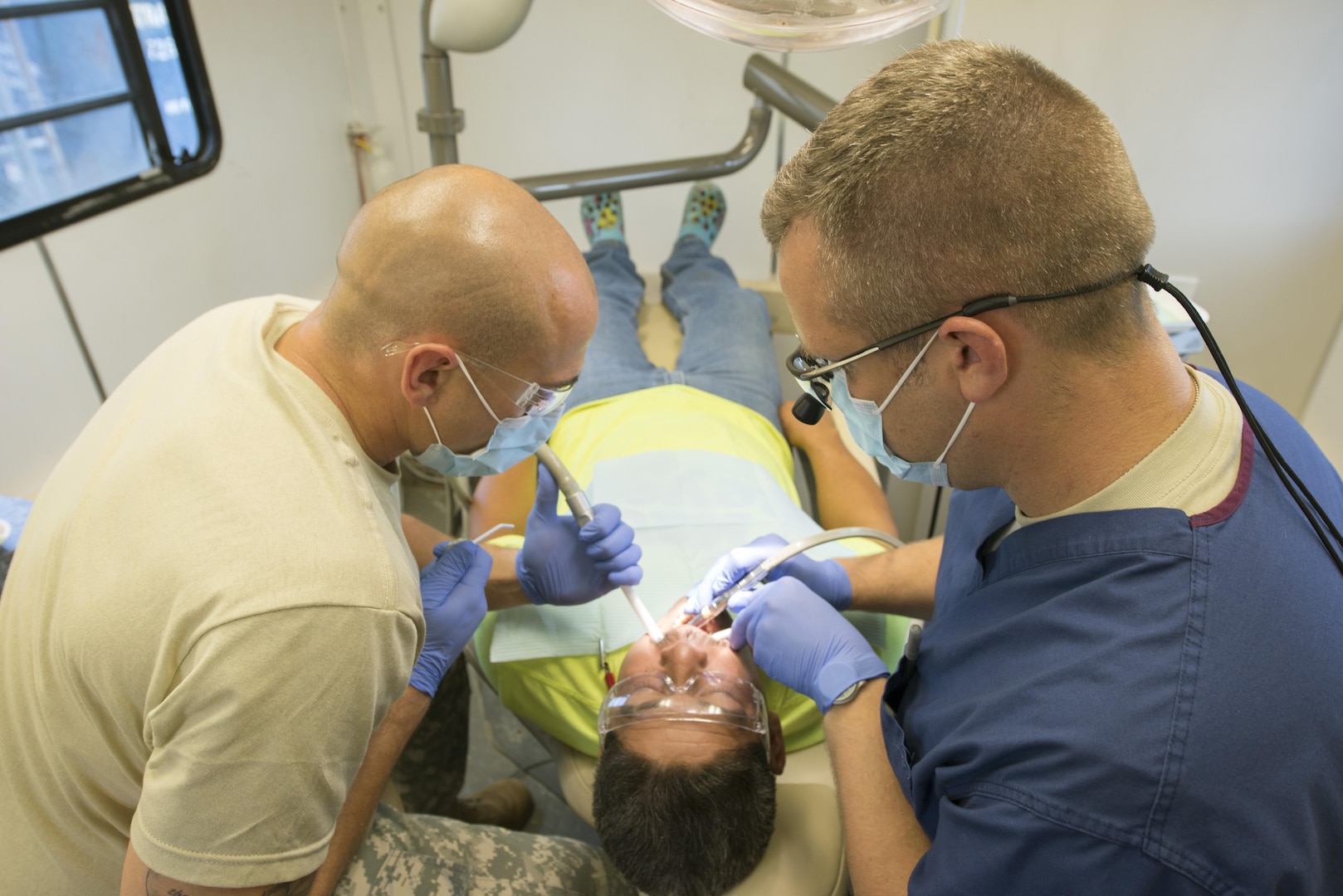 Capt. Mark Burns (right) and Sgt. Justin Miles (left), both Reserve Soldiers with the 7226th Medical Support Unit, perform a dental procedure on Victor Garcia inside a mobile dental clinic parked next to the El Cenizo Community Center June 20. Nearly 200 Soldiers and five Navy opticians participated in an Innovative Readiness Training mission to provide free medical care and other services to economically distressed colonias in the Laredo area near the Texas-Mexico border.