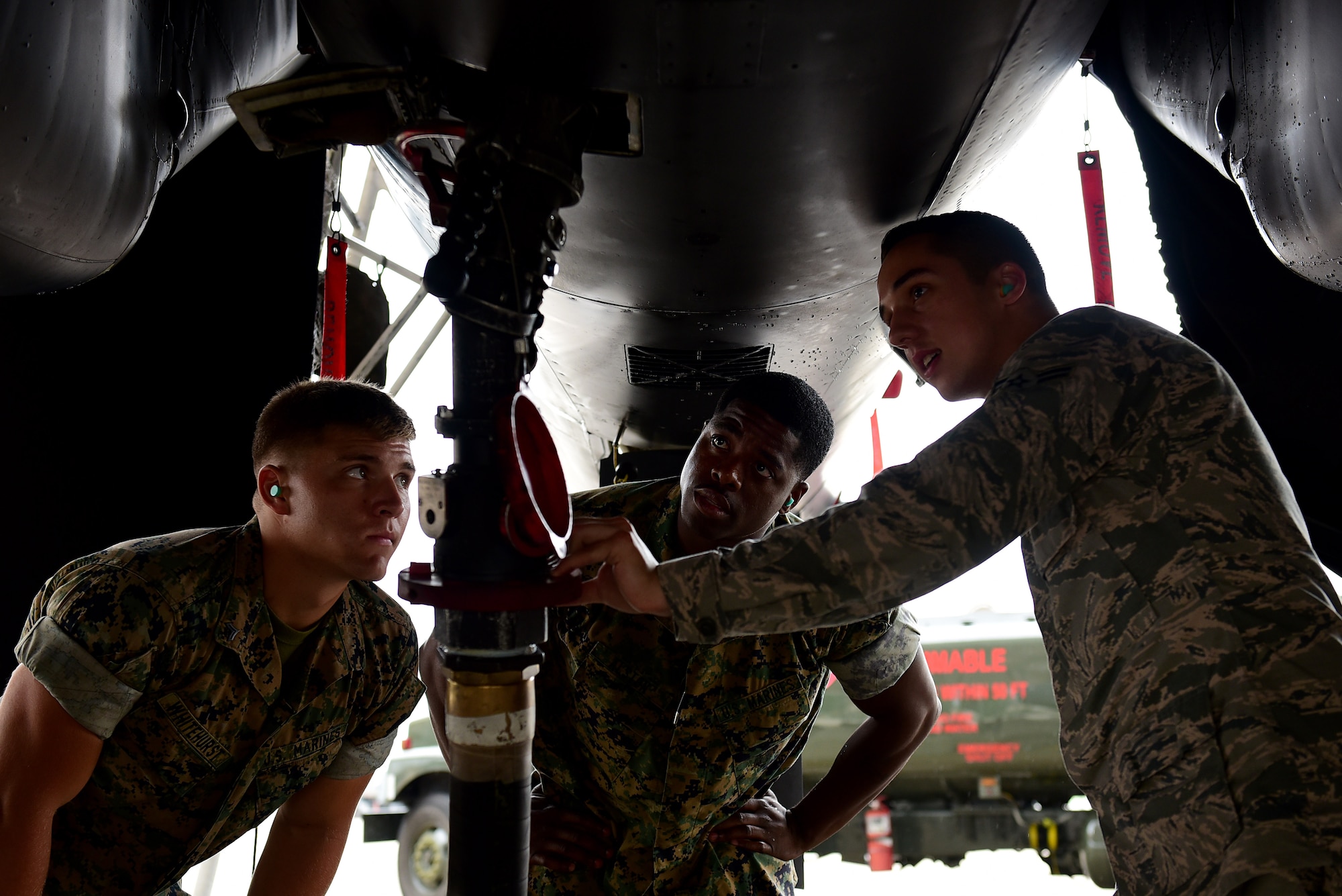 U.S. Marine Corps Lance Cpl. Austin Whitehurst, Marine Wing Support Squadron 271 bulk fuel specialist (left), Staff Sergeant David Alston, MWSS 271 platoon sergeant (middle), and Airman 1st Class Scott Plante Jr., 4th Logistics Readiness Squadron fuels specialist (right), refuel an F-15E Strike Eagle, June 22, 2017, at Seymour Johnson Air Force Base, North Carolina. Airmen trained Marines in a two-day joint training exercise to familiarize the Marines with the R-11 aircraft refueler before their deployment to Morón Air Base, Spain. (U.S. Air Force photo by Airman 1st Class Kenneth Boyton)