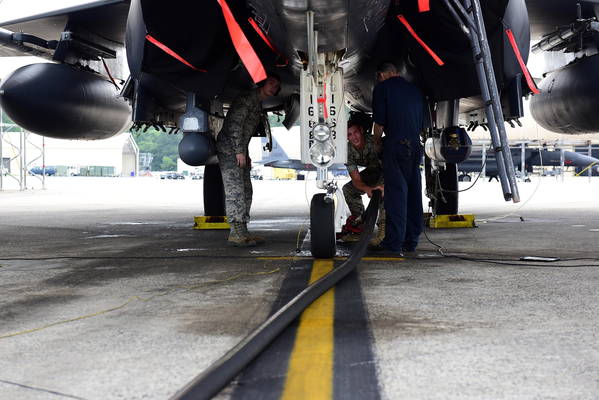 Airman Bryan Roy, 4th Logistics Readiness Squadron fuels specialist, and U.S. Marine Corps Cpl. Andrew Morris, Marine Wing Support Squadron 271 bulk fuel specialist, prepare to attach a fuel line to an F-15E Strike Eagle for refueling, June 22, 2017, at Seymour Johnson Air Force Base, North Carolina. The Marines received hands-on training with R-11 aircraft refueling vehicles before deploying to Morón Air Base, Spain. (U.S. Air Force photo by Airman 1st Class Kenneth Boyton)