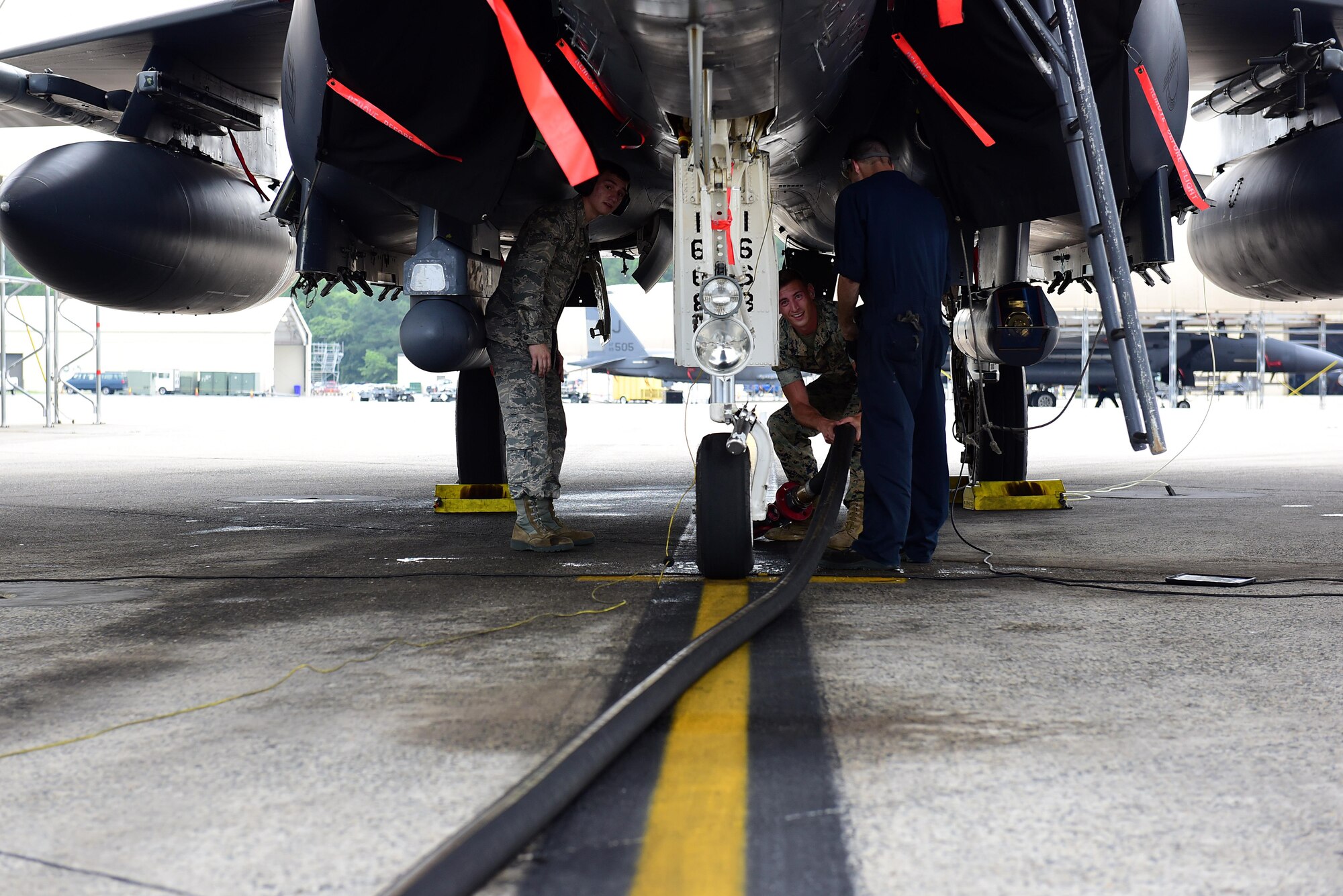 Airman Bryan Roy, 4th Logistics Readiness Squadron fuels specialist, and U.S. Marine Corps Cpl. Andrew Morris, Marine Wing Support Squadron 271 bulk fuel specialist, prepare to attach a fuel line to an F-15E Strike Eagle for refueling, June 22, 2017, at Seymour Johnson Air Force Base, North Carolina. The Marines received hands-on training with R-11 aircraft refueling vehicles before deploying to Morón Air Base, Spain. (U.S. Air Force photo by Airman 1st Class Kenneth Boyton)