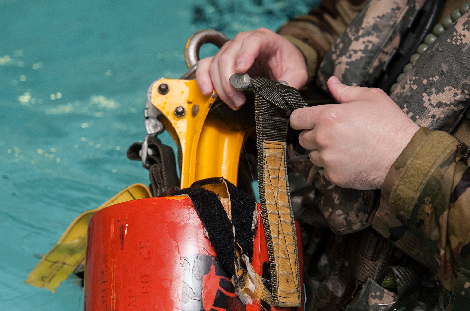 A 54th Helicopter Squadron Airman fastens a forest penetrator at Minot Air Force Base, N.D., June 22, 2017. The 54th HS uses forest penetrators as recovery devices for people on land and water. (U.S. Air Force photo by Airman 1st Class Jonathan McElderry)