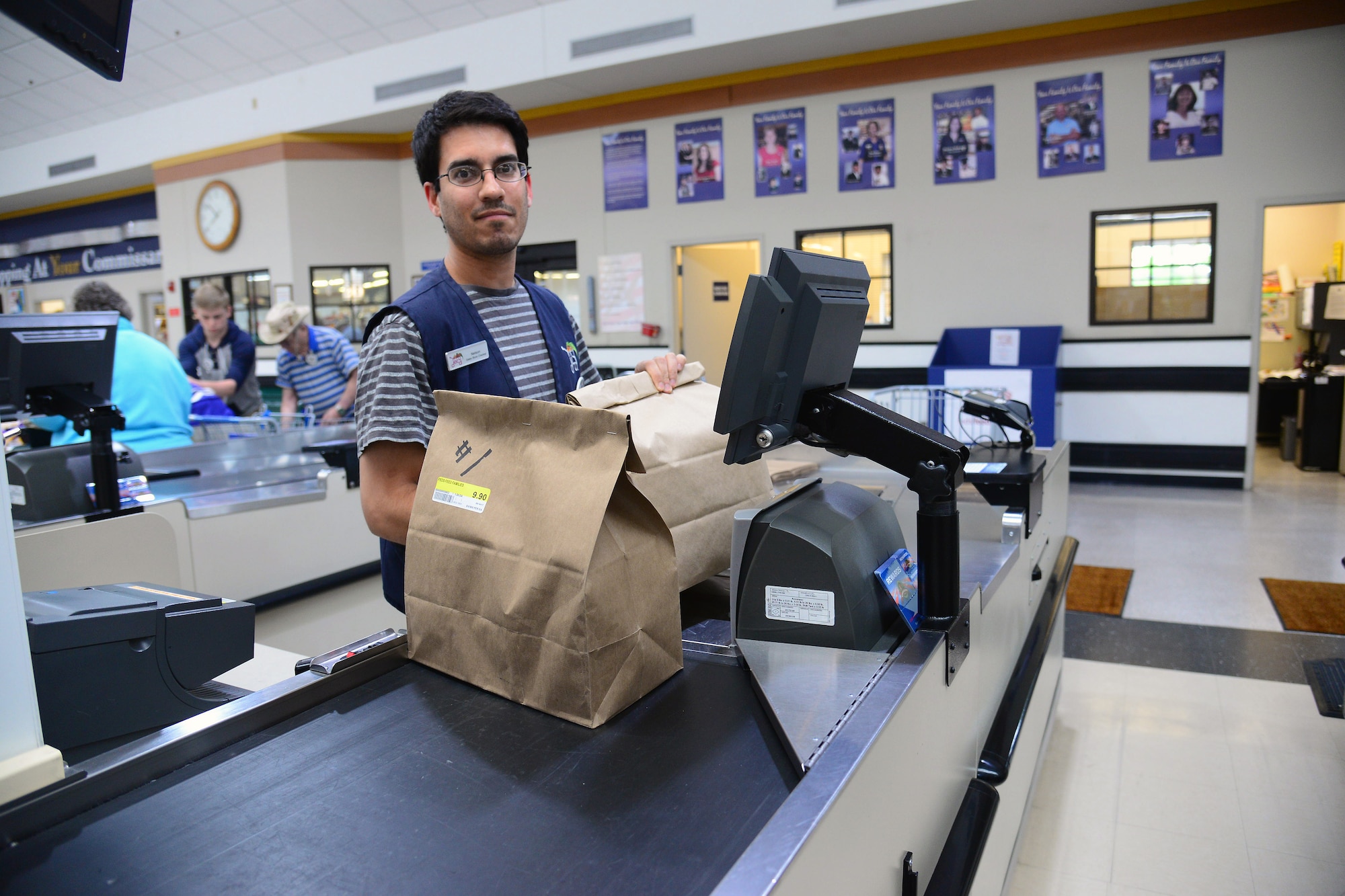A commissary teller rings up a customer’s purchase of two Feds Feed Families donation bags June 29, 2017, at Malmstrom Air Force Base, Mont. The Malmstrom Commissary acts as a direct link between the donating customers and the local charity for distribution. (U.S. Air Force photo/Senior Airman Magen M. Reeves)