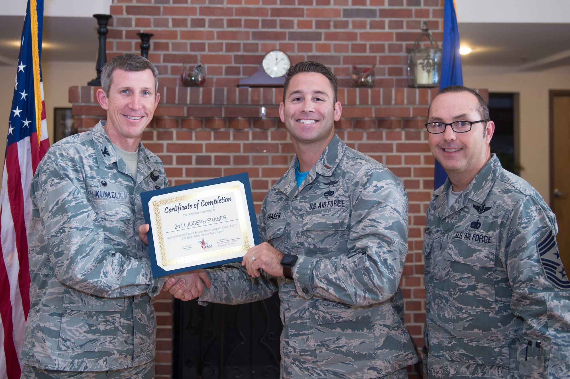 Col. Thomas Kunkel, 23d Wing commander, presents a certificate to 2nd Lt. Joseph Fraser, 23d Communications Squadron officer in charge of plans and programs, during the 2017 Emerge Moody, Leadership Moody graduation ceremony, June 23, 2017, at Moody Air Force Base, Ga. Approximately 30 distinguished Airmen accepted honors during the event. During the nine-month program, Emerge Moody students broadened their view of how they fit into the overall Moody and larger Air Force mission, while Leadership Moody students learned local community agencies' best practices and challenges of leaders from non-military perspectives. (U.S. Air Force photo by Senior Airman Greg Nash)