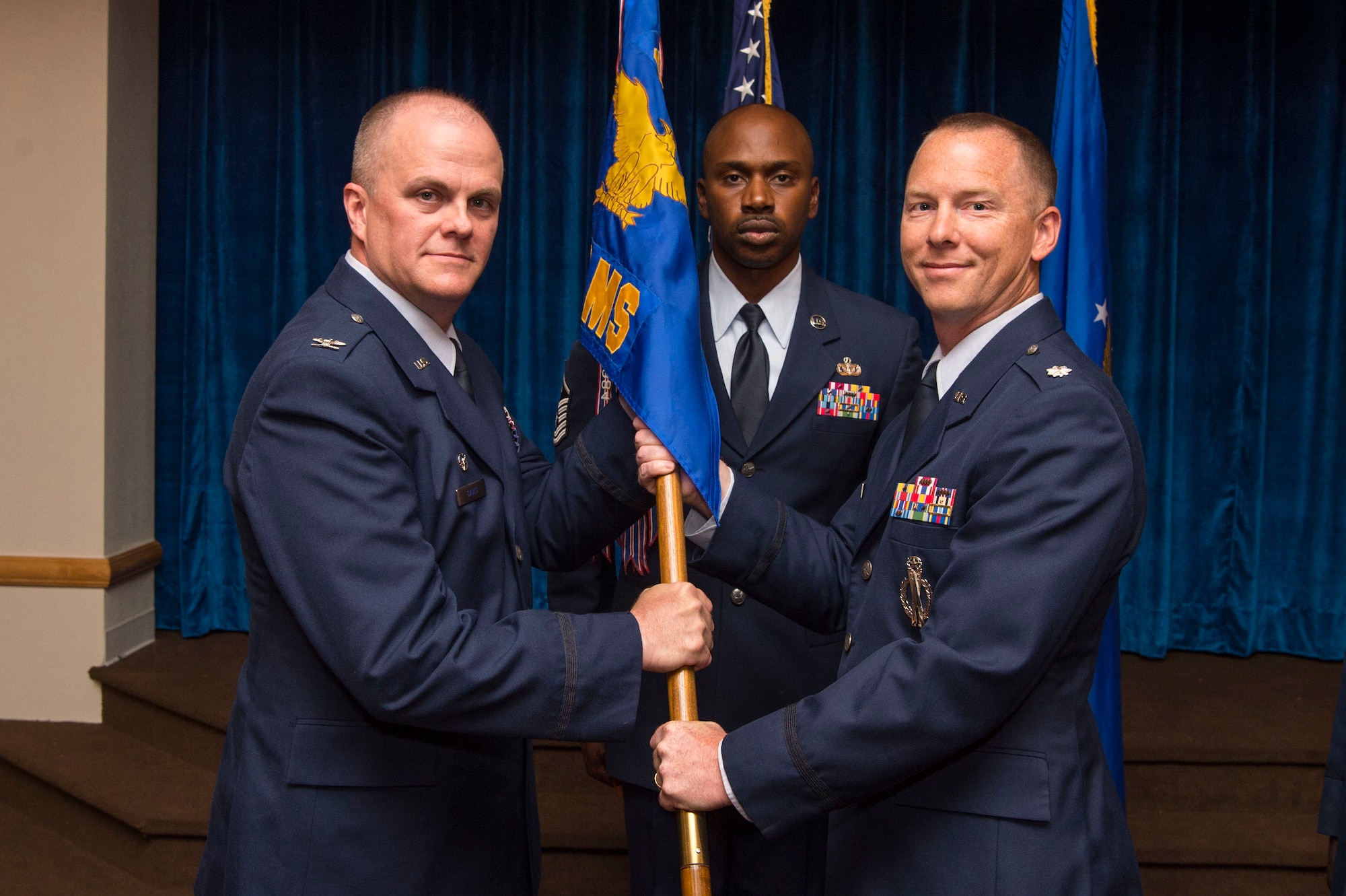 Col. Todd Sauls, 90th Operations Group commander, passes the guidon to Lt. Col. Joel Douglas, 321st Missile Squadron commander, during the 321st MS change of command ceremony at F.E. Warren Air Force Base, Wyo., June 29, 2017. The ceremony signified the transition of command from Lt. Col. Johnny Galbert. (U.S. Air Force photo by Staff Sgt. Christopher Ruano)