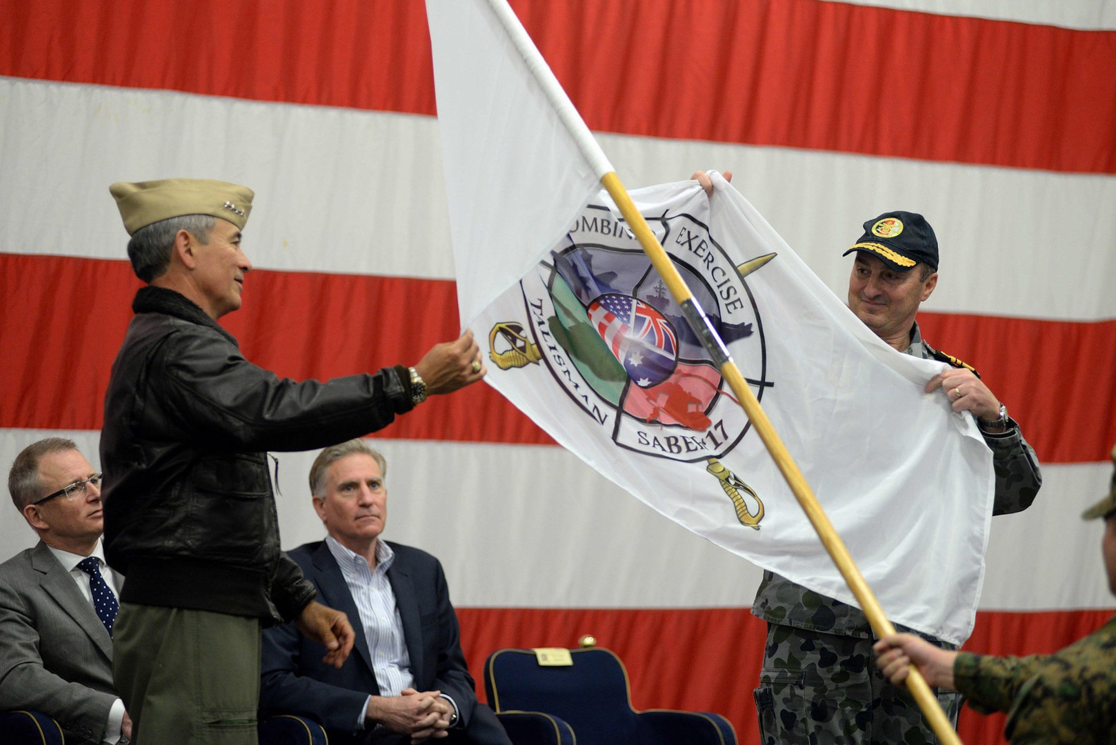 Adm. Harry B. Harris, commander of U.S. Pacific Command, left, and Royal Australian Navy Vice Adm. David Johnston, Australian Defense Force Chief of Joint Operations, unfurl the ceremonial Talisman Saber 2017 flag during the Talisman Saber 2017 opening ceremony aboard the amphibious assault ship USS Bonhomme Richard (LHD 6), June 29, 2017. Talisman Saber is a biennial U.S.-Australia bilateral military exercise that combines a field training exercise and command post exercise to strengthen interoperability and response capabilities to uphold the tenets of the U.S.-Australian alliance. 