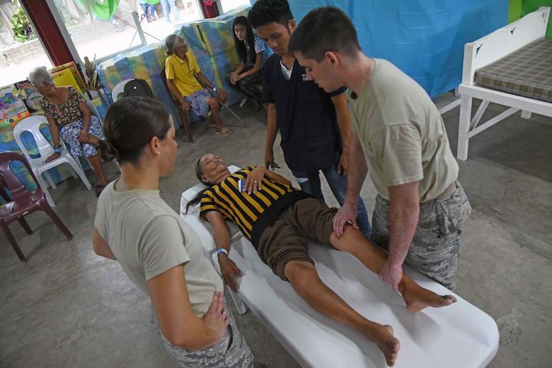 The 2017 Pacific Angel physical therapy team works on a woman from Bogo City during PACANGEL in Northern Cebu Province, Philippines, June 26, 2017. PACANGEL participants from six different nations work together with local nongovernmental organizations to administer medical care, including general health, optometry, dental, physical therapy and pediatrics, to the people of Northern Cebu Province. (U.S. Air Force photo by Tech. Sgt. Jeff Andrejcik)