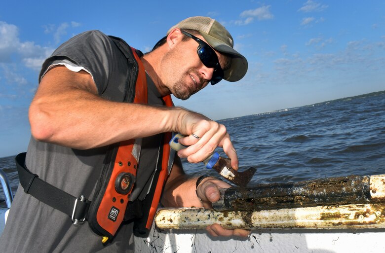 Mobile Bay Coastal Engineer Richard Allen cleans ocean muck off a gauge as part of the regular servicing effort for extensive data collection in the bay and delta for the Mobile Harbor General ReEvaluation Report, or GRR.