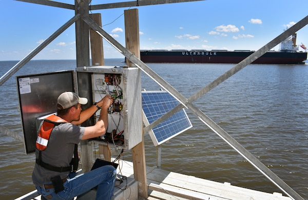 Sitting atop the U.S. Coast Guard navigation range in Mobile Bay, Coastal Engineer Richard Allen connects newly-installed gauges to the broadcast system which provides data communication to the Corps of Engineers. The gauges measure water level, wave height, turbidity, salinity and suspended sediment concentration.