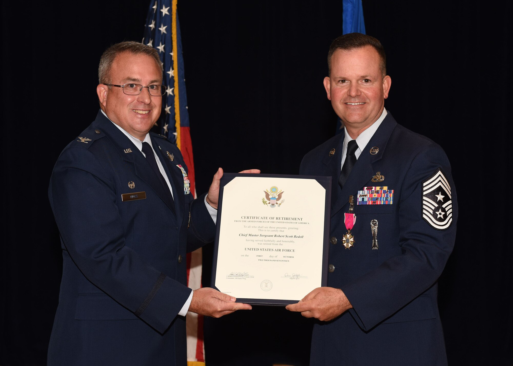 Retired Col. J. Christopher Moss, former 30th Space Wing commander, presents a certificate of retirement to Chief Master Sgt. Robert Bedell, 30th SW command chief, June 29, 2017, Vandenberg Air Force Base, Calif. Bedell, who served for 29 years, sat down before his retirement for some final words to the base to share years of experience and expertise with fellow Airmen one final time as a command chief. (U.S. Air Force photo by Senior Airman Kyla Gifford/Released)
