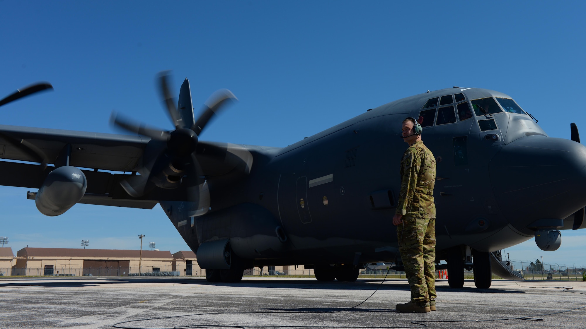 Staff Sgt. Philip Palmer, a C-130 Super Hercules loadmaster assigned to the 71st Rescue Squadron, Moody Air Force Base, Ga., watches a C-130 prime for flight during exercise Combat Raider at Ellsworth AFB, S.D., June 28, 2017. The C-130 is a versatile aircraft capable of performing combat search and rescue missions and refueling other aircraft. (U.S. Air Force photo by Airman Nicolas Z. Erwin)