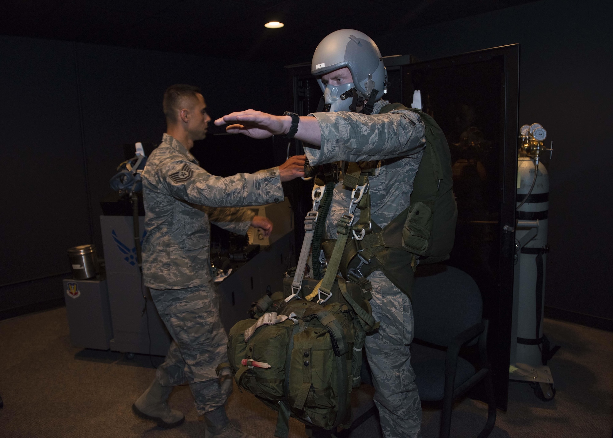 Tech. Sgt. Oscar Pena, 92nd Aerospace Medicine technician, moves to assist Airman 1st Class Jeff Eisberg, 22nd Training Group Survival Evasion Resistance and Evasion specialist, during a Reduced Oxygen Breathing Device simulation June 26, 2017, at Fairchild Air Force Base, Washington. Pilots, air crew and parachutists are trained to raise their left arm to signal they need help when experiencing the effects of hypoxia.
(U.S. Air Force Photo / Airman 1st Class Ryan Lackey)