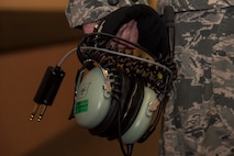 U.S. Air Force Senior Airman Christopher McWhorter, a 610th Air Control Flight weapons director, walks down the hallway with an air controller headset during RED FLAG-Alaska, at Eielson Air Force Base, Alaska, June 20, 2017. The headset provides controllers with zero noise pollution so they can clearly communicate to all players in the airspace. While in Misawa Air Base, Japan, controllers coordinate with Japan Air Self-Defense Force's 3rd Air Wing to work on interoperability which further strengthens their tactical fluidity. (U.S. Air Force photo by Airman 1st Class Sadie Colbert)