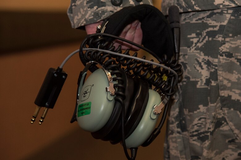U.S. Air Force Senior Airman Christopher McWhorter, a 610th Air Control Flight weapons director, walks down the hallway with an air controller headset during RED FLAG-Alaska, at Eielson Air Force Base, Alaska, June 20, 2017. The headset provides controllers with zero noise pollution so they can clearly communicate to all players in the airspace. While in Misawa Air Base, Japan, controllers coordinate with Japan Air Self-Defense Force's 3rd Air Wing to work on interoperability which further strengthens their tactical fluidity. (U.S. Air Force photo by Airman 1st Class Sadie Colbert)