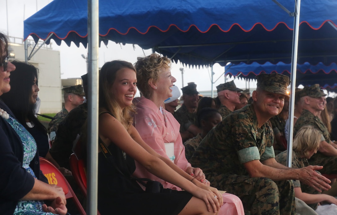 U.S. Marine Corps Maj. Gen. Russell A. Sanborn, outgoing 1st Marine Aircraft Wing commanding general and his wife Linda Sanborn laugh during Lt. Gen. Lawrence D. Nicholson's speech at a change of command ceremony on Marine Corps Air Station Futenma, Okinawa, Japan, June 29, 2017. Sanborn relinquished command to Brig. Gen. Thomas D. Weidley. Sanborn will assume command at Marine Forces Europe and Africa. (U.S. Marine Corps photo by Lance Cpl. Isabella Ortega)