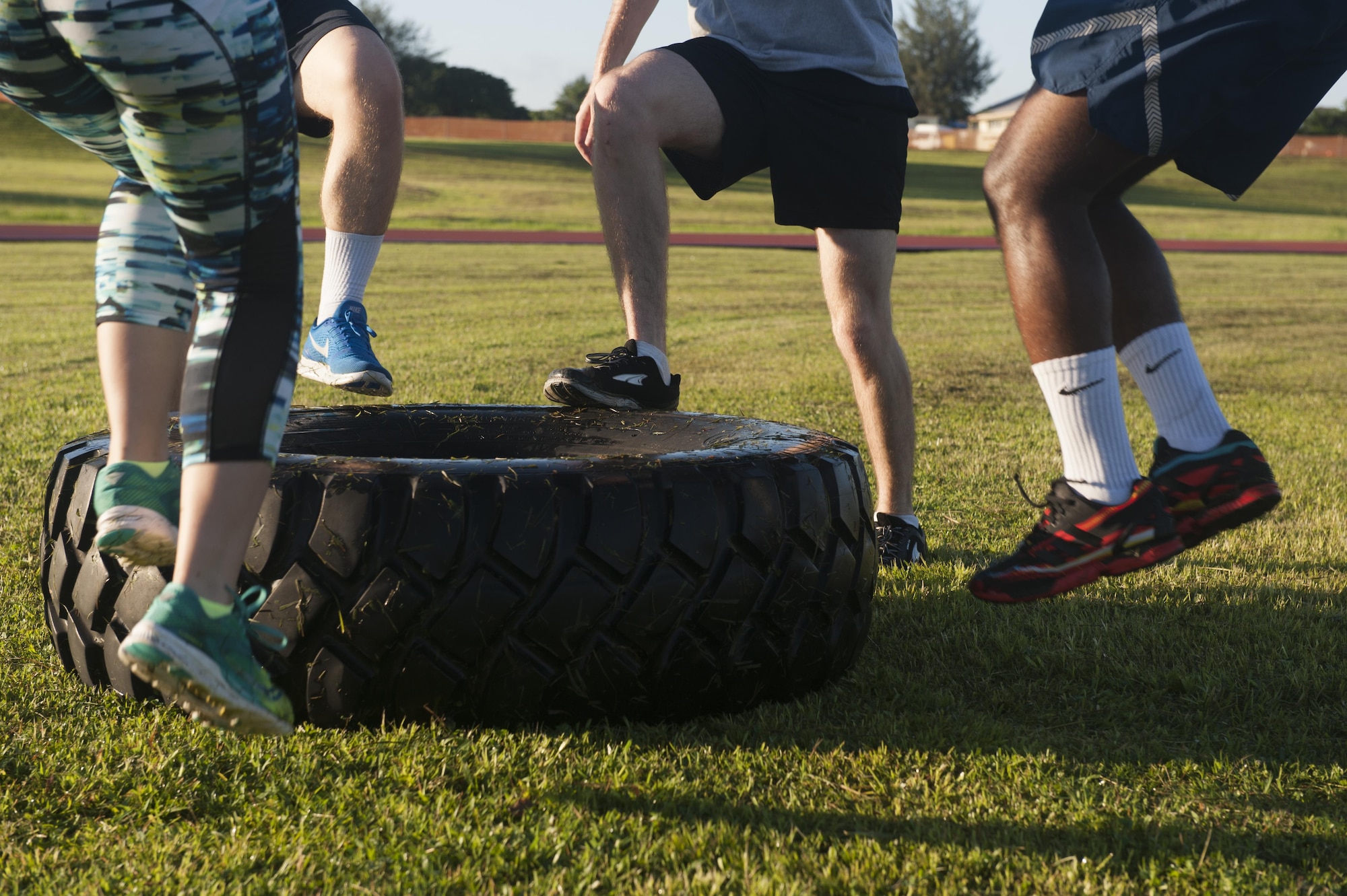 Warrior Training Fitness workout attendees use the tire exercise station June 28, 2017, at the Risner Fitness and Sports Complex, Kadena Air Base, Japan. The workout consisted of multiple exercise stations that rotate between varieties of training techniques. (U.S. Air Force photo/Airman 1st Class Greg Erwin)