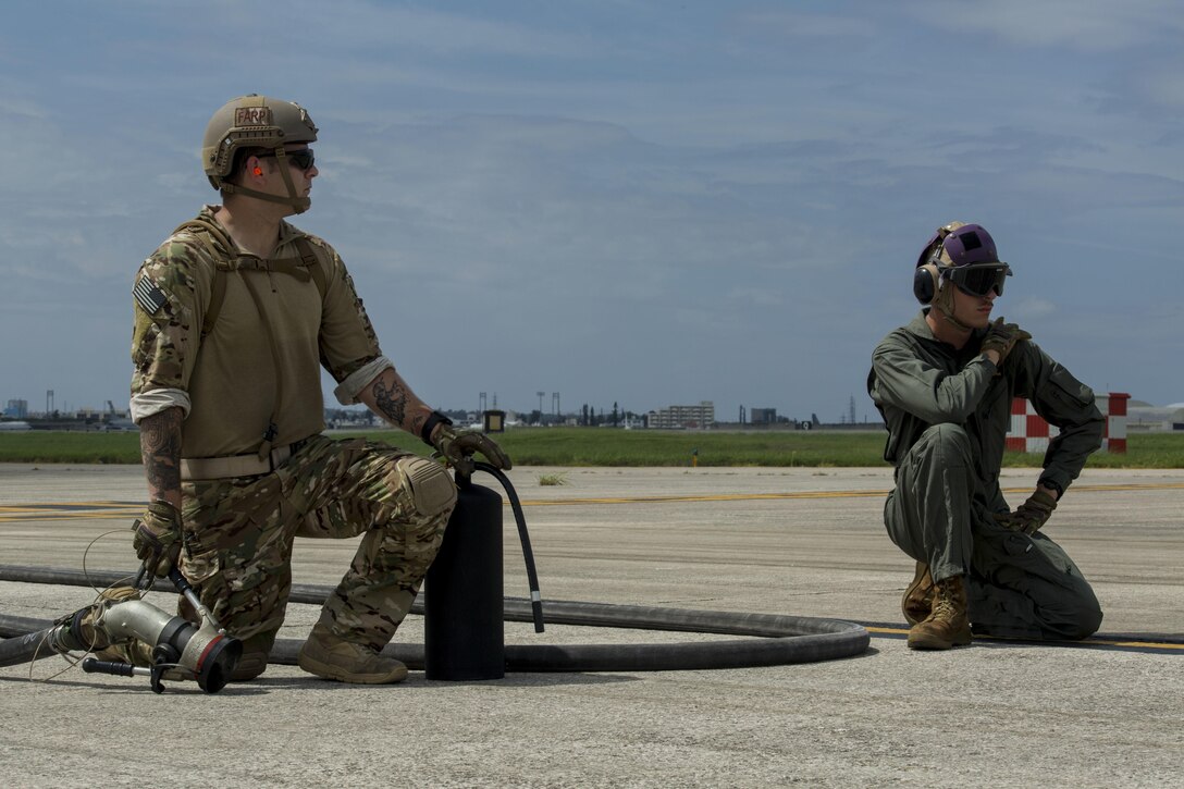 Air Force Staff Sgt. Mark Goddard and Lance Cpl.  Westley W. Joints await the arrival of an F-35B Lightning II aircraft with Marine Fighter Attack Squadron 121 at Kadena Air Force Base, Okinawa, Japan, June 27, 2017.  Goddard is a bulk fuel specialist with 18th Logistics and Readiness Squadron, 353 Special Operations Group, 18th Wing. Joints is a bulk fuel specialist with Marine Wing Support Squadron 172, Marine Aircraft Group 36, 1st Marine Aircraft Wing, III Marine Expeditionary Force. The two-day exercise enabled the U.S. Air Force and Marine Corps to improve interoperability and develop tactics, techniques and procedures involving the new aircraft for future joint FARP operations throughout the Indo-Asia Pacific Theater. VMFA-121 is based out of Iwakuni, Japan. (U.S. Marine Corps photo by Lance Cpl. Deseree Kamm)