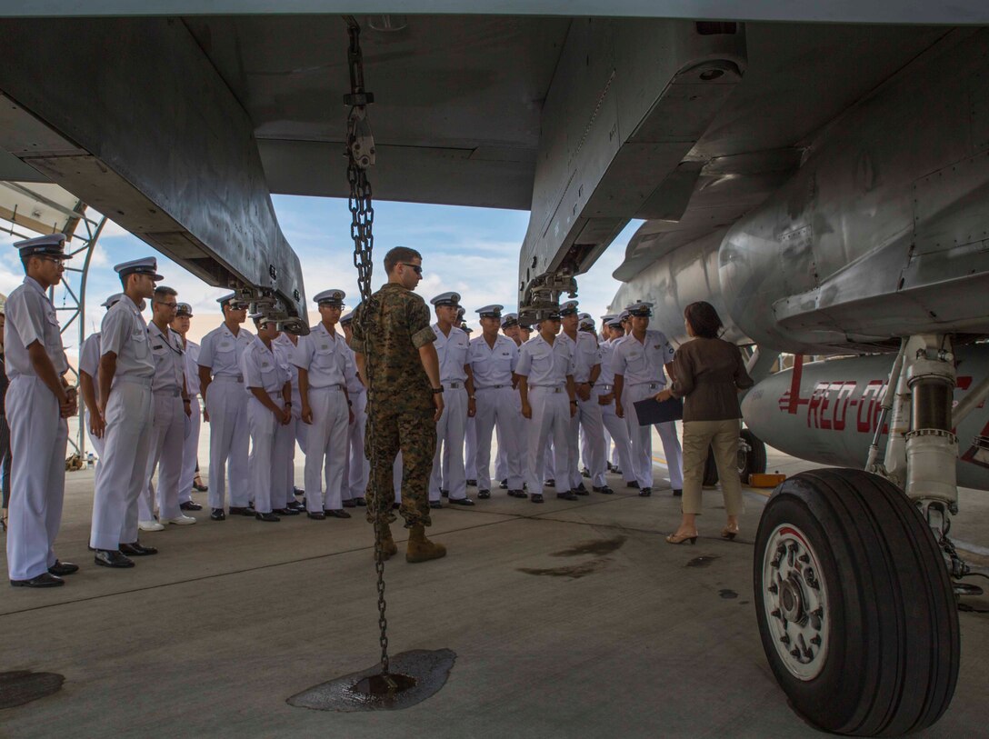 Japan Maritime Self-Defense Force aviation students ask questions about F/A-18 Hornets during a Junior Officer Exchange Program visit at Marine Corps Air Station Iwakuni, Japan, June 21, 2017. Students came from Ozuki Air Base to learn about Marine Air Group (MAG) 12 and the F/A-18. They familiarized themselves with the aircraft during the visit by taking part in a flight simulator and by visiting a static display. (U.S. Marine Corps photo by Lance Cpl. Gabriela Garcia-Herrera)