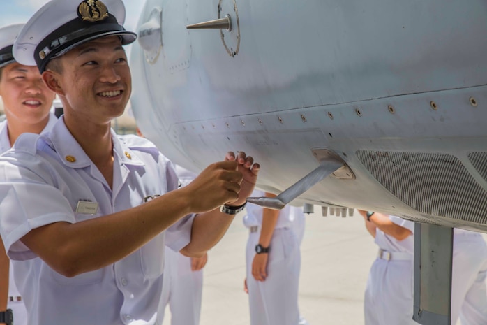 Japan Maritime Self-Defense Force Petty Officer 3rd Class Testsuro, a JMSDF aviation student, looks at an F/A-18C Hornet during a Junior Officer Exchange Program visit at Marine Corps Air Station Iwakuni, Japan, June 21, 2017. Students came from Ozuki Air Base to learn about Marine Air Group (MAG) 12 and the F/A-18. They familiarized themselves with the aircraft during the visit by taking part in a flight simulator and by visiting a static display. (U.S. Marine Corps photo by Lance Cpl. Gabriela Garcia-Herrera)