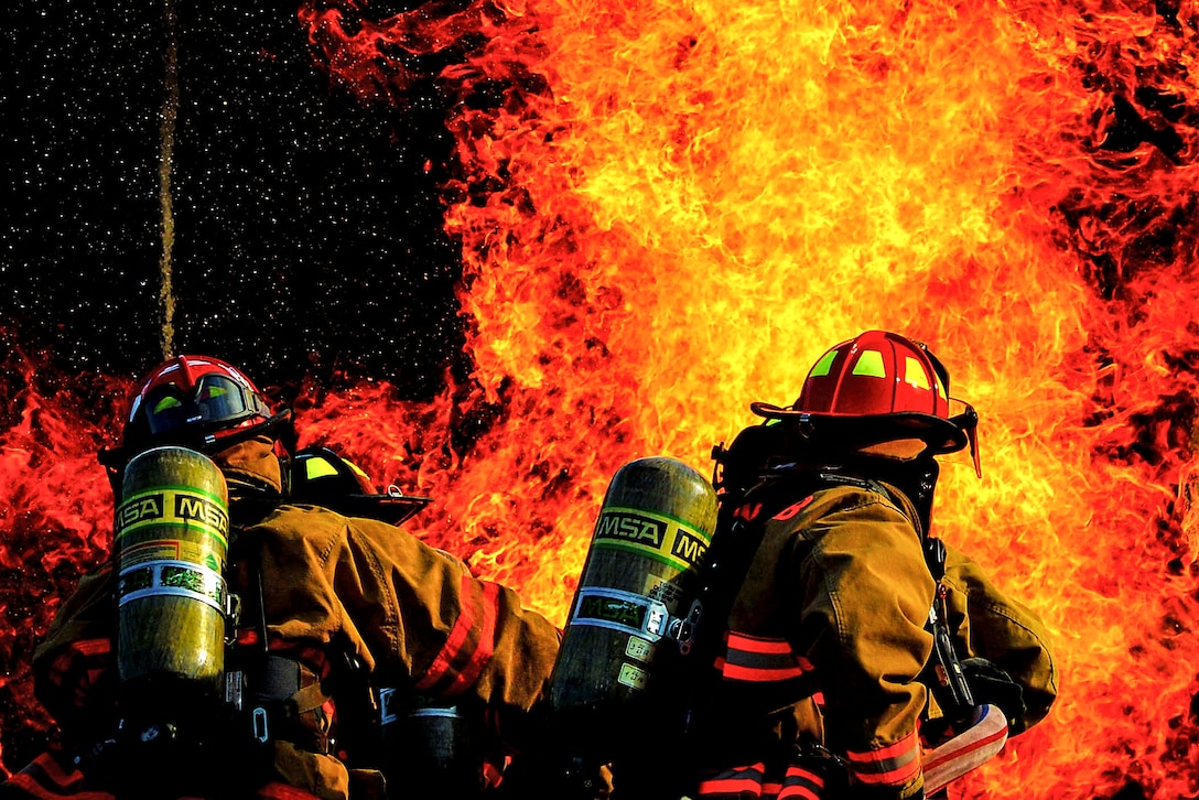 Airmen extinguish a fire during a training scenario at Shaw Air Force Base, S.C., June 27, 2017. The airmen are assigned to the 20th Civil Engineer Squadron fire department. Air Force photo by Senior Airman Christopher Maldonado