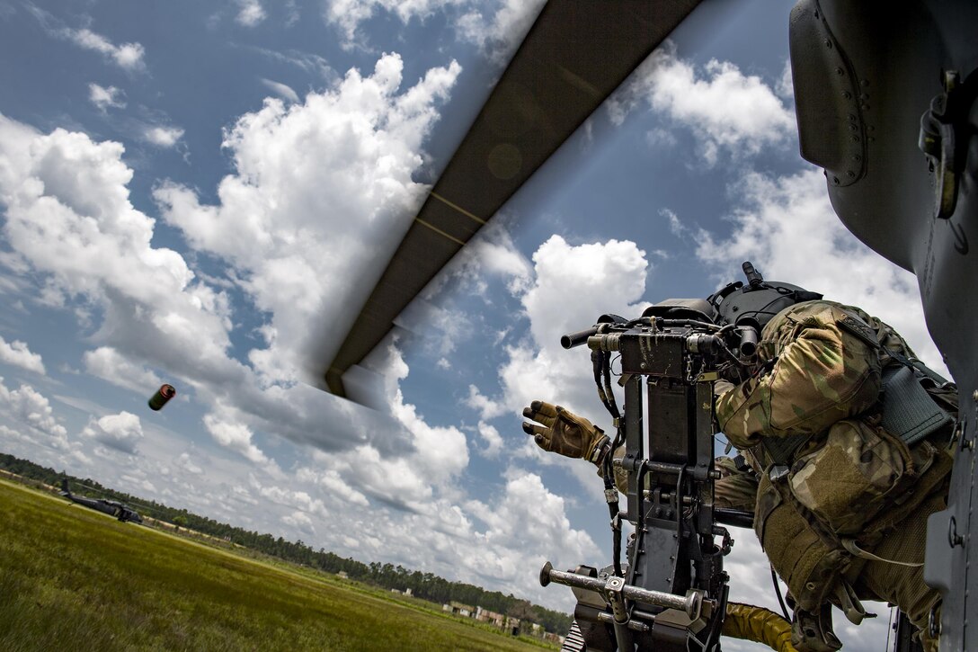 Air Force Tech. Sgt. Brandon Middleton tosses a smoke grenade from an HH-60G Pave Hawk helicopter during training at Moody Air Force Base, Ga., June 27, 2017, Middleton is a special missions aviator assigned to the 41st Rescue Squadron. Air Force photo by Staff Sgt. Ryan Callaghan