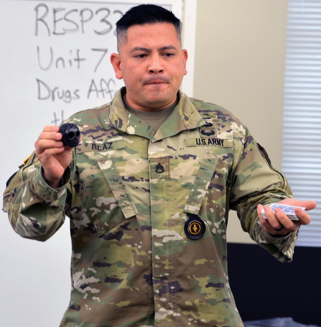 Staff Sgt. John Blaz, Interservice Respiratory Therapy Program instructor at the Medical Education and Training Campus, Joint Base San Antonio-Fort Sam Houston, performs a magic trick with a deck of cards for his students at the beginning of a recent class.
