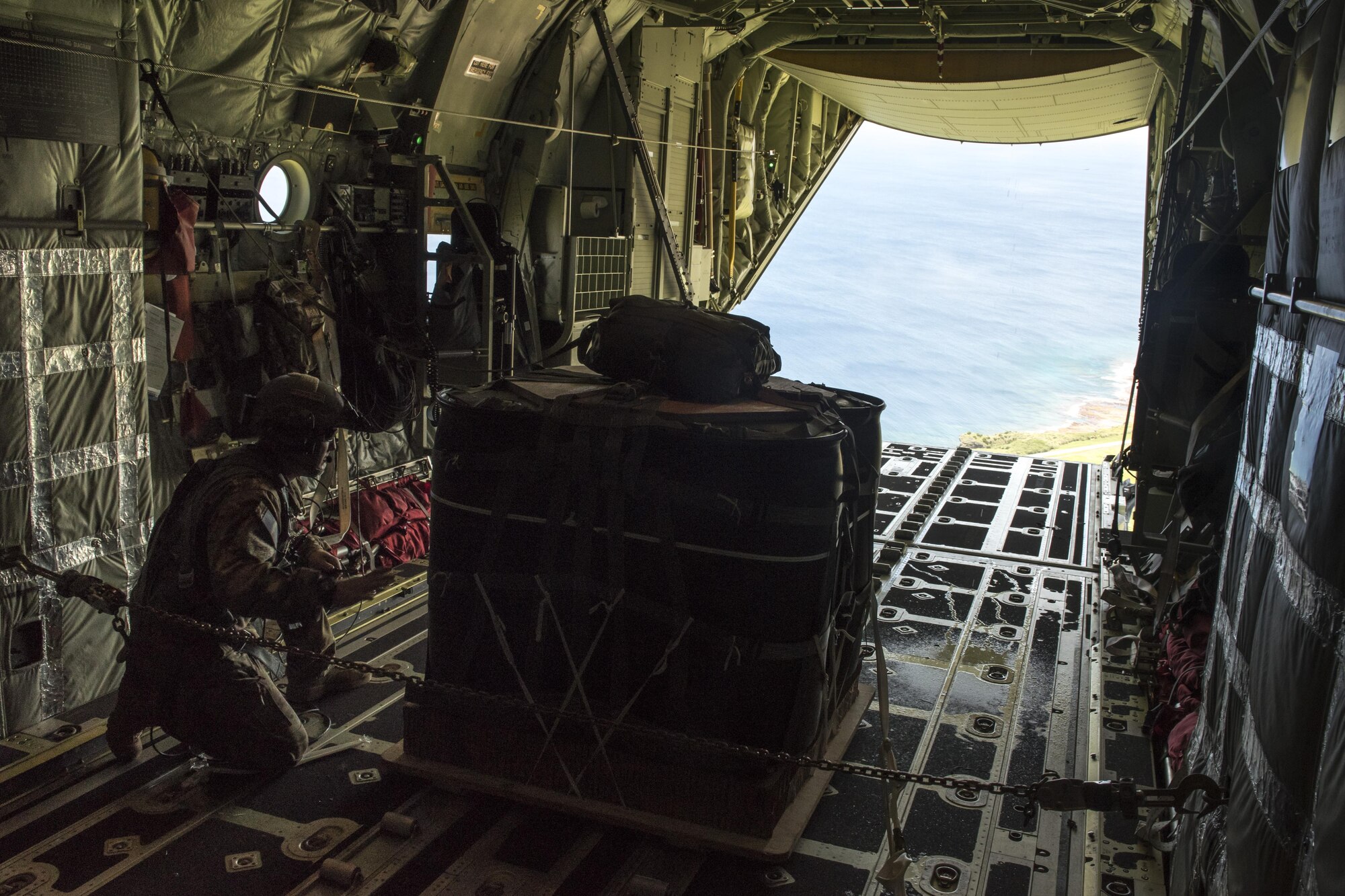 A U.S. Air Force MC-130J Commando II loadmaster from the 17th Special Operations Squadron prepares to airdrop a package onto Le Shima Range, Okinawa, Japan, during a mass launch training mission June 22, 2017. Aircrews must consider a number of variables in order to execute a precise and effective airdrop, to include wind speed, aircraft velocity, altitude, location and timing.  (U.S. Air Force photo by Senior Airman John Linzmeier)
