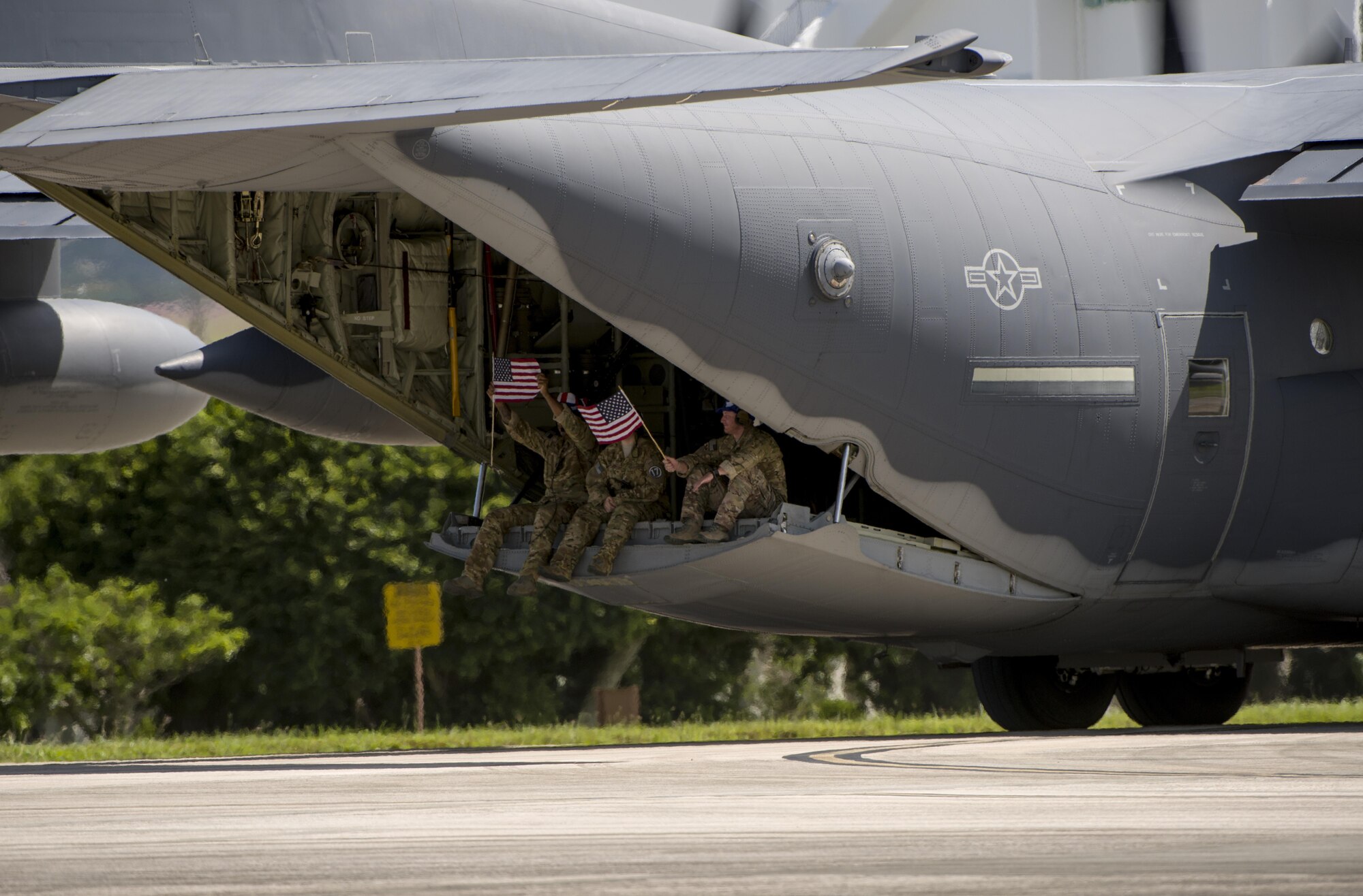 U.S. Air Force MC-130J Commando II aircrew from the 17th Special Operations Squadron wave to onlookers before leaving for a mass launch training mission June 22, 2017 at Kadena Air Base, Japan. Airmen from the 17th SOS conduct training operations often to ensure constant readiness to perform a variety of high-priority, low-visibility missions throughout the Indo-Asia Pacific Region. (U.S. Air Force photo by Senior Airman Omari Bernard)