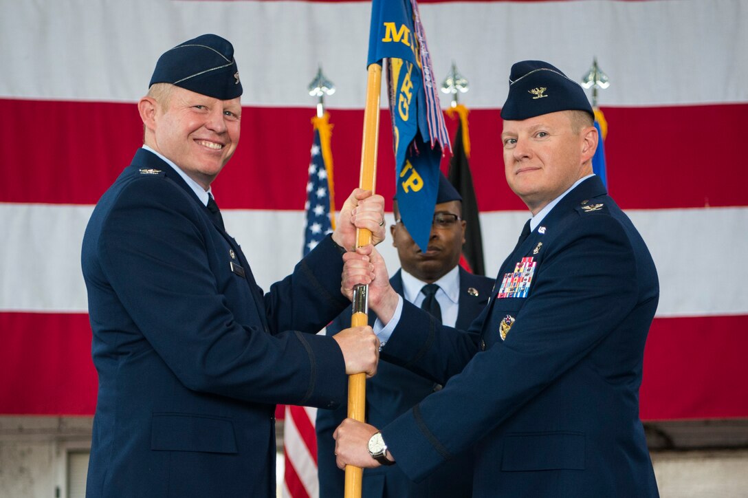 U.S. Air Force Col. Joseph McFall, 52nd Fighter Wing commander, left, gives the ceremonial guidon to U.S. Air Force Col. Edward LaGrou, incoming 52nd Medical Group commander, right, during the 52nd MDG change of command ceremony at Spangdahlem Air Base, Germany, June 29, 2017. (U.S. Air Force photo by Senior Airman Preston Cherry)
